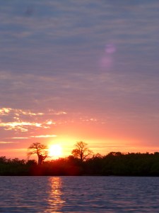 sun set watched gliding along a river in Sokone in a pirogue surrounded by laughing and chatting friends who kept shouting 