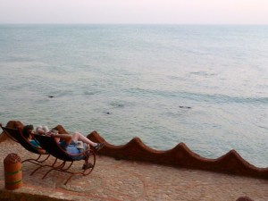 usa parents watch the sun set over the ocean in toubab diallo